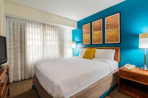 夏洛特夏洛特南方公园原住客栈的一间卧室设有一张床和蓝色的墙壁