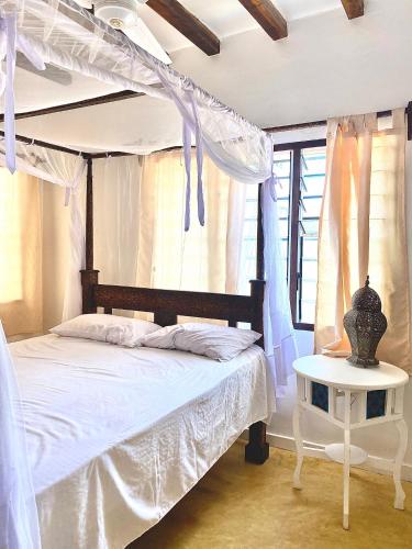 拉穆Beautiful Mafriza Apartment的卧室配有白色的床和桌子