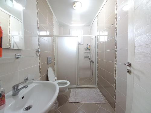 费特希耶Perfect Holiday Condo at Central Fethiye Best for Families的带淋浴、卫生间和盥洗盆的浴室