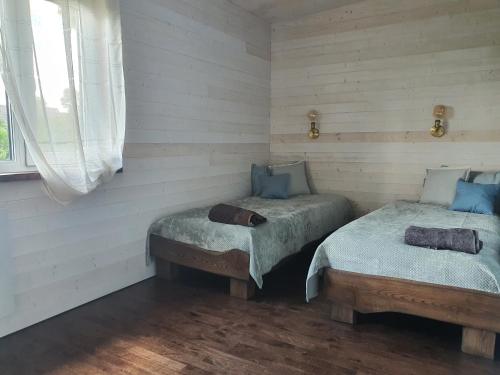 KalniHoliday House "Sea Nest"的白色墙壁客房中的两张单人床