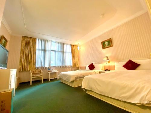 桃园市丽华商务大饭店 的酒店客房设有两张床和一台平面电视。