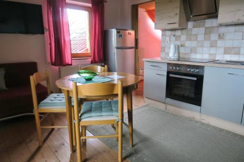 申贝格Ferienwohnung Degner的厨房配有桌椅和冰箱。
