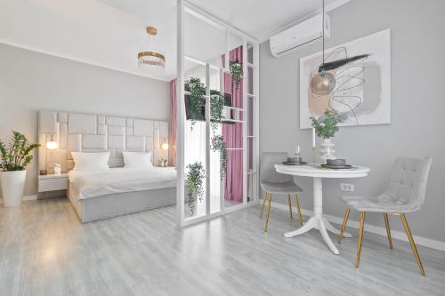 奥拉迪亚Andreea Studio的白色卧室配有床和桌椅