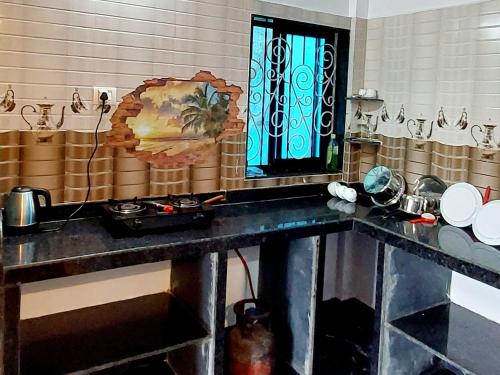 曼德姆Green House Stay的厨房配有带水槽的柜台和窗户。