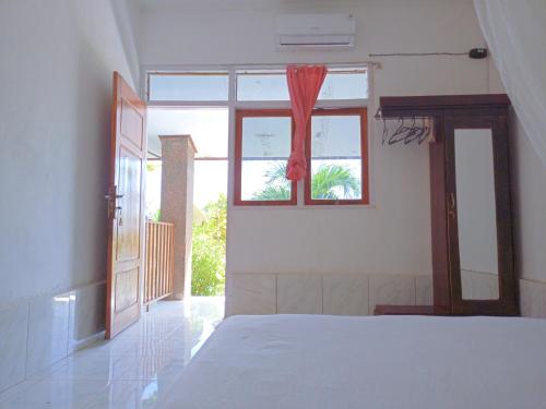 HuuRocky homestay lakey nangas beach的卧室配有白色的床和窗户。