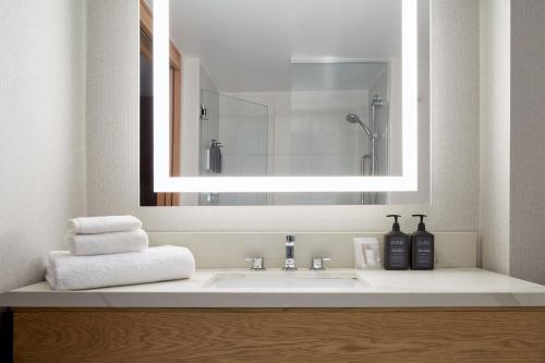 多瓦尔蒙特利尔机场喜来登酒店的一间带大镜子的盥洗盆的浴室