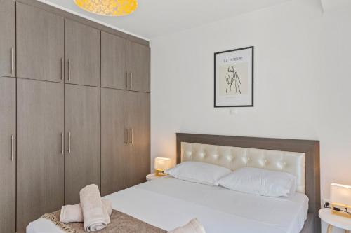 罗德镇Rhodian Filoxenia的卧室配有白色的床和木制橱柜。