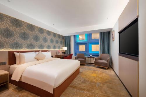 广州广州万国元宝酒店-珠江新城店的配有一张床和一台平面电视的酒店客房