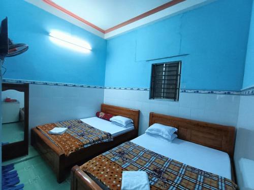 芹苴Khách sạn Ngọc Mai 2的蓝色墙壁客房的两张床