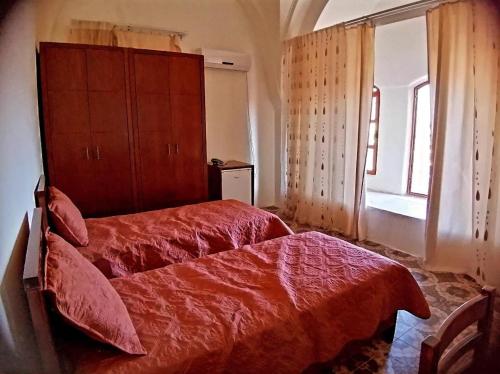 希伯仑Lamar Guesthouse - Hebron的一间卧室设有红色的床和窗户。