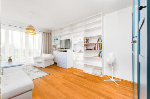 华沙Czapelska 40 by Homeprime的客厅拥有白色的墙壁和木地板。