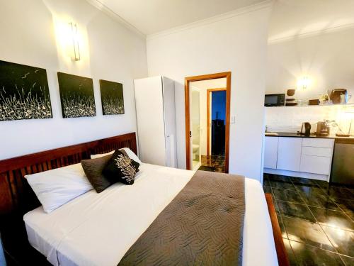 埃尔利海滩Bella Vista on Nara Stay 4n each guest get free Day trip Kens Klassic Kombi的一间带白色床的卧室和一间厨房