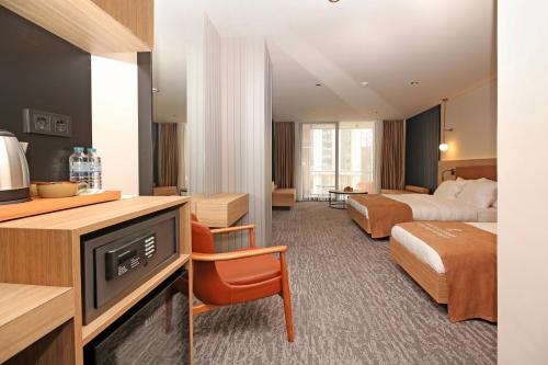 Yomraİnanlar City Hotel的酒店客房设有两张床和电视。
