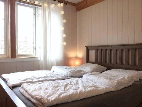 克里斯蒂安桑Cosy flat for 4 persons的一间卧室设有两张带白色床单的床和窗户。