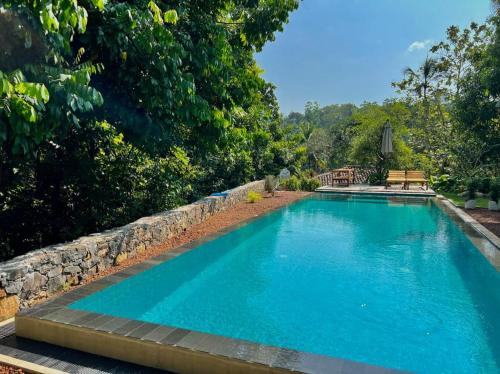 高尔The Jungle Loft Galle的一座带石墙的大型蓝色游泳池