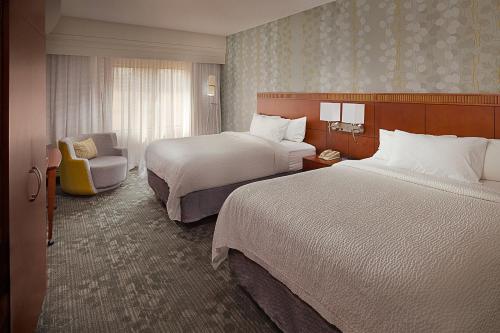哈里斯堡哈里斯堡赫氏万怡酒店的酒店客房,配有两张床和椅子