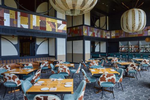 京都Ace Hotel Kyoto的餐厅设有木桌和椅子及灯