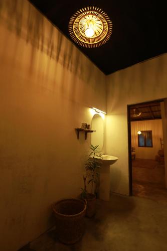 帕西库达Kirãmam Villa的浴室设有镜子、水槽和灯