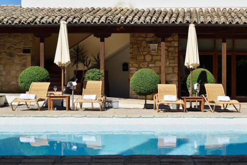 巴埃萨月亮门酒店的一组椅子和遮阳伞,位于游泳池旁