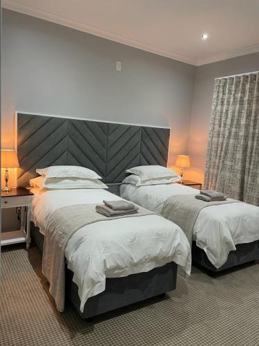 克拉伦斯6 Sleeper Villa Clarens Golf Estate的一间带两张床和大床头的卧室