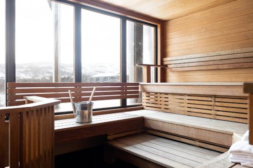 耶卢Highland Lodge Fjellandsby的一间带木墙和大窗户的桑拿浴室
