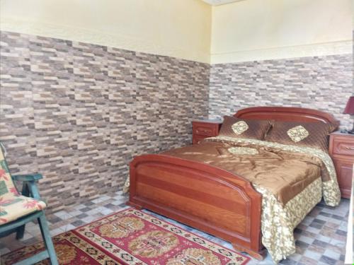 Oulad AkkouVilla的一间卧室设有一张床和砖墙