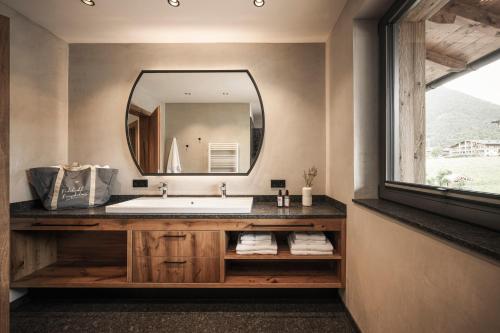 佩尔蒂绍Wagnerhof Apartments的一间带大镜子和盥洗盆的浴室