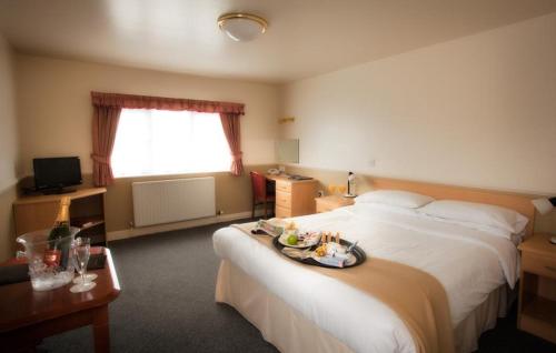 彻克莫尔顿公园酒店的一间酒店客房,配有两张床,床上放着一个食物盘