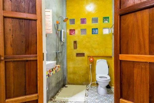 清莱纳拉克奥度假酒店的黄色的浴室设有卫生间和水槽