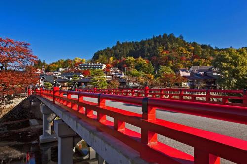 高山hotel around TAKAYAMA, Ascend Hotel Collection的山上的桥梁上的红栅栏