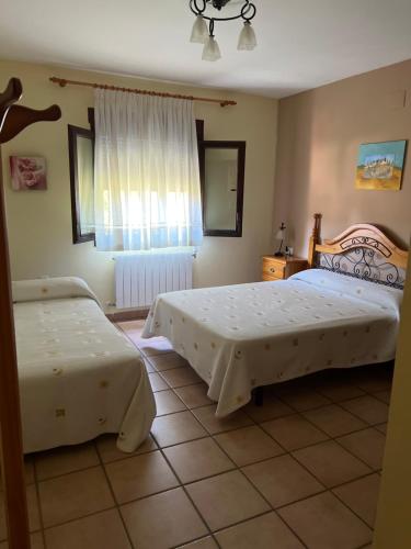 比利亚尔瓦德拉谢拉Apartamentos Los Parrales的一间卧室设有两张床和窗户。