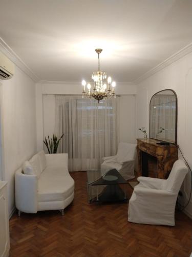 布宜诺斯艾利斯las cañitas libertador的客厅配有白色家具和吊灯。