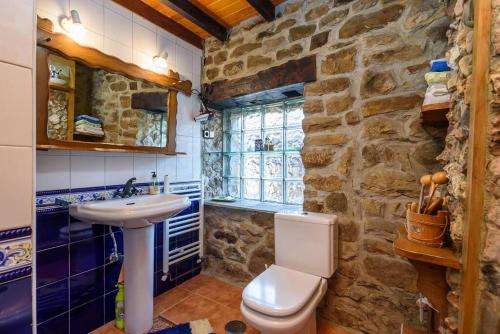 CasoLa Casa Rectoral de El Tozu的石质浴室设有水槽和卫生间