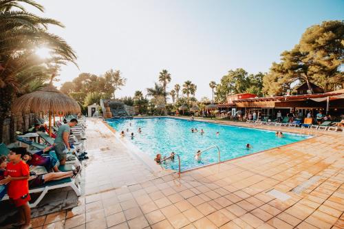 塔马里特喀里多尼亚露营酒店的度假村的游泳池,人们在里面游泳