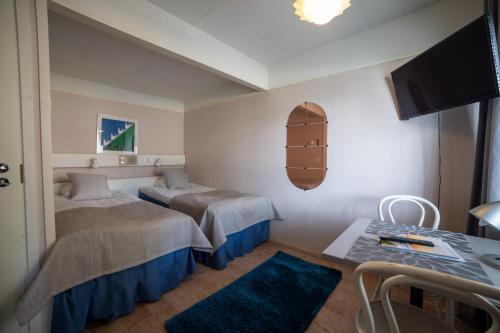 卡拉约基Rantakallan Rinne rivitalohuoneet的酒店客房设有两张床和一张桌子。