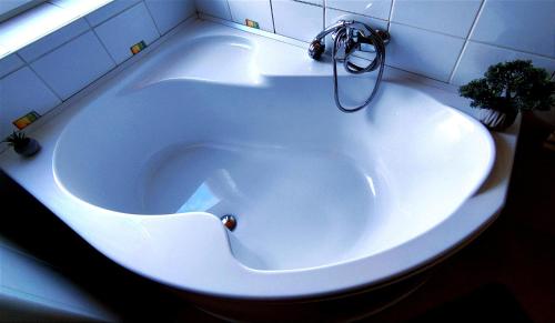 绍尔戈陶尔扬Imádni Való Sarokkádas Apartman Salgótarján belvárosában的浴室内设有带水龙头的白色浴缸