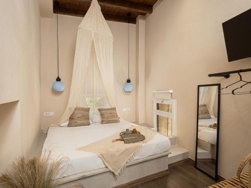 干尼亚Artemide city places _Leon tiny suite的卧室配有一张带镜子的白色大床