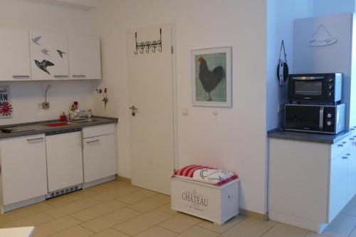 孔茨Apartment Am Markt 13的厨房配有白色橱柜、微波炉和冰箱。