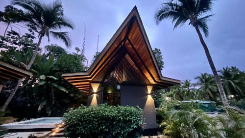 别霍港Namu Garden Hotel & Spa的棕榈树三角形屋顶的房子