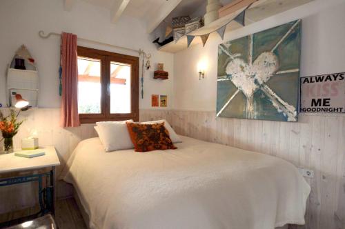 科斯提克斯Casa con piscina en bonito entorno Mia的卧室配有白色的床和窗户。