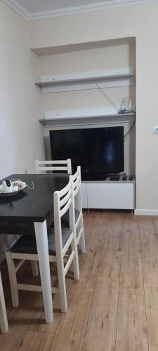 吉诺卡斯特Brand New Apartment Gjirokaster的一间带桌椅和电视的用餐室