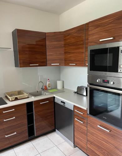 科希策Jahodná的厨房配有木制橱柜和不锈钢用具