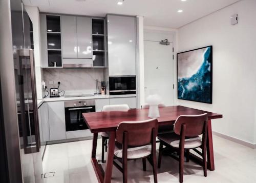 富查伊拉Address Resort Apartments Fujairah - 2 bedroom apartment的厨房配有木制用餐室的桌椅