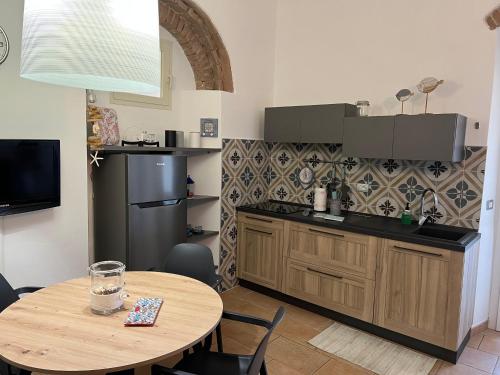 圣温琴佐Appartamento Vaticano的厨房配有木桌和一张带桌子的小桌子。