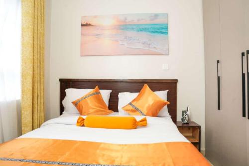 奈瓦沙Kelly homes in Naivasha的一间卧室配有带橙色和白色枕头的床