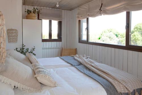 MejoradaFinca San Benito, piscina privada, a estrenar!的卧室配有带枕头的白色床和窗户。