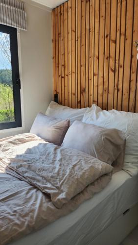 OFFGRID Haus am Angelteich的一张带白色床单和枕头的床,靠窗