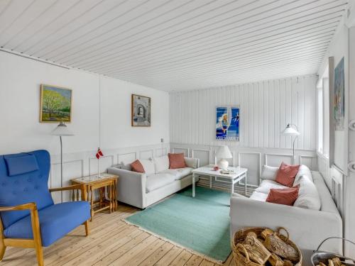瓦伊厄斯斯特兰德Holiday Home Gaelle - 800m from the sea in Western Jutland by Interhome的客厅配有白色家具和蓝色椅子