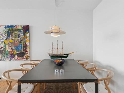 埃贝尔托夫特Apartment Geert - 25m from the sea in Djursland and Mols by Interhome的一间用餐室,配有黑色的桌子和椅子