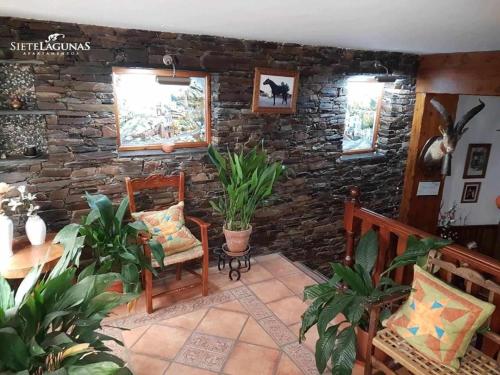 特雷韦莱斯APARTAMENTOS SIETE LAGUNAS的客厅配有两把椅子和石墙